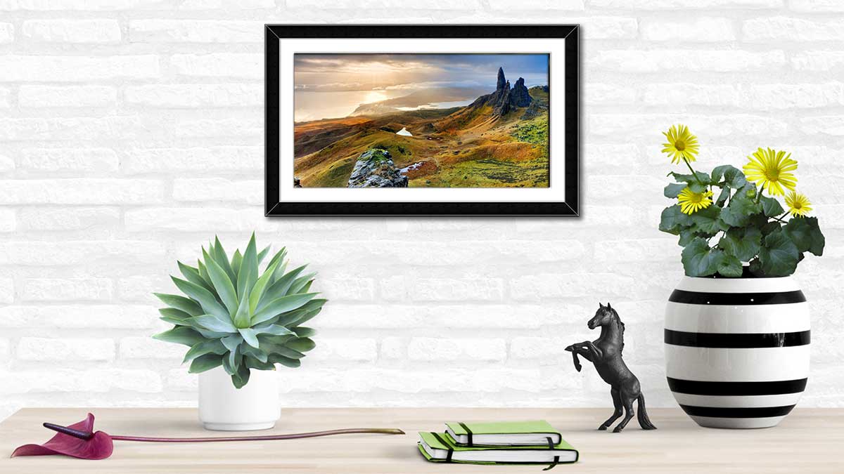 Picture of the Scottish highlands printed and framed on a white brick wall
