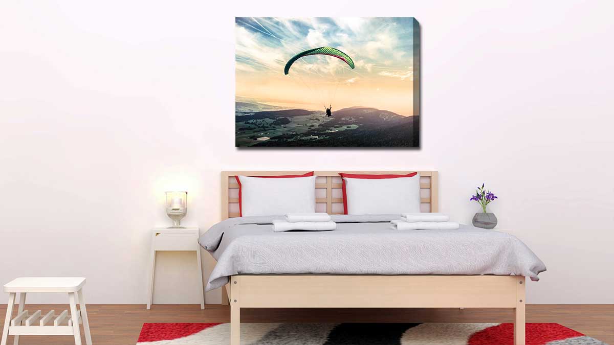 Adventure photo of hang gliding on a canvas print, hung in a bedroom over the bed
