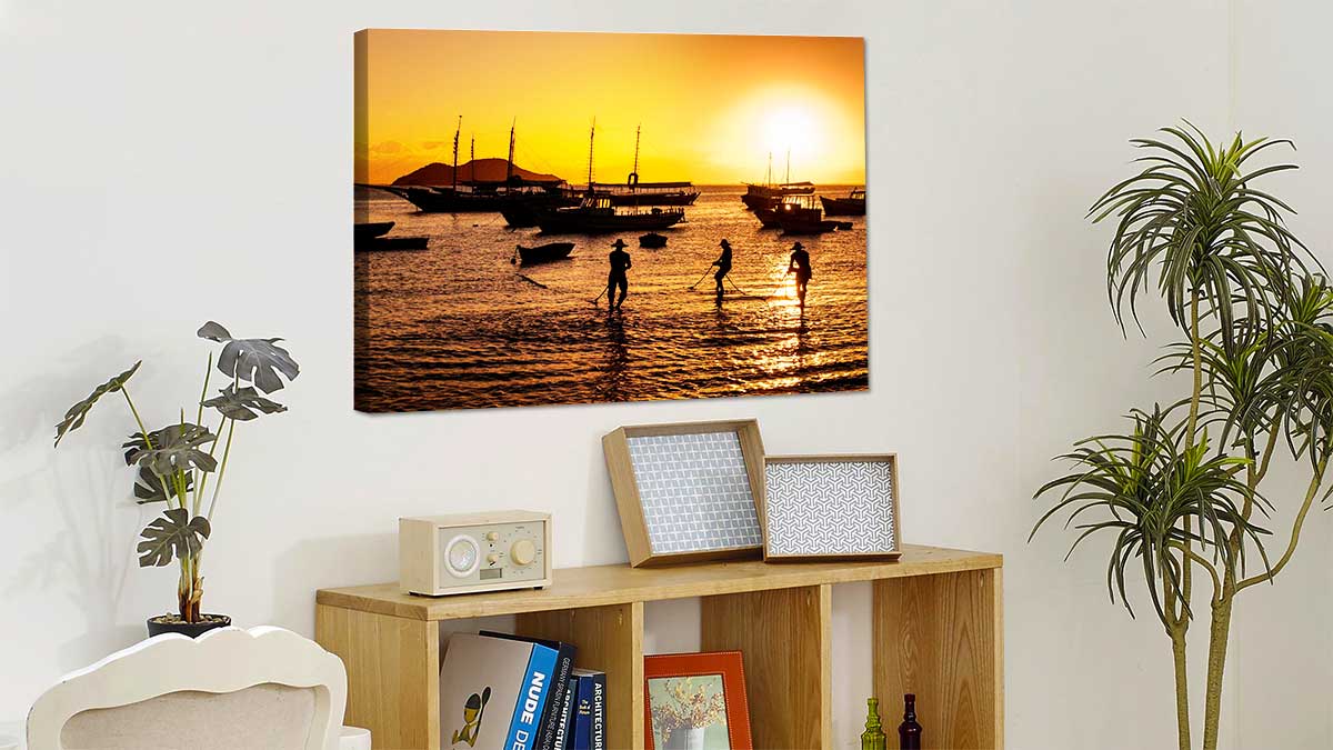 Travel photo featuring fishermen in the sunset, printed onto canvas and hung over a bookcase
