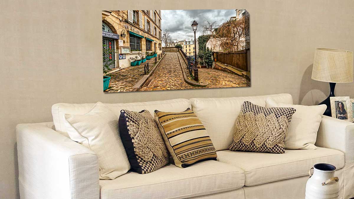 Canvas print created from a picture of a cobbled city street, hung over a comfy cream settee