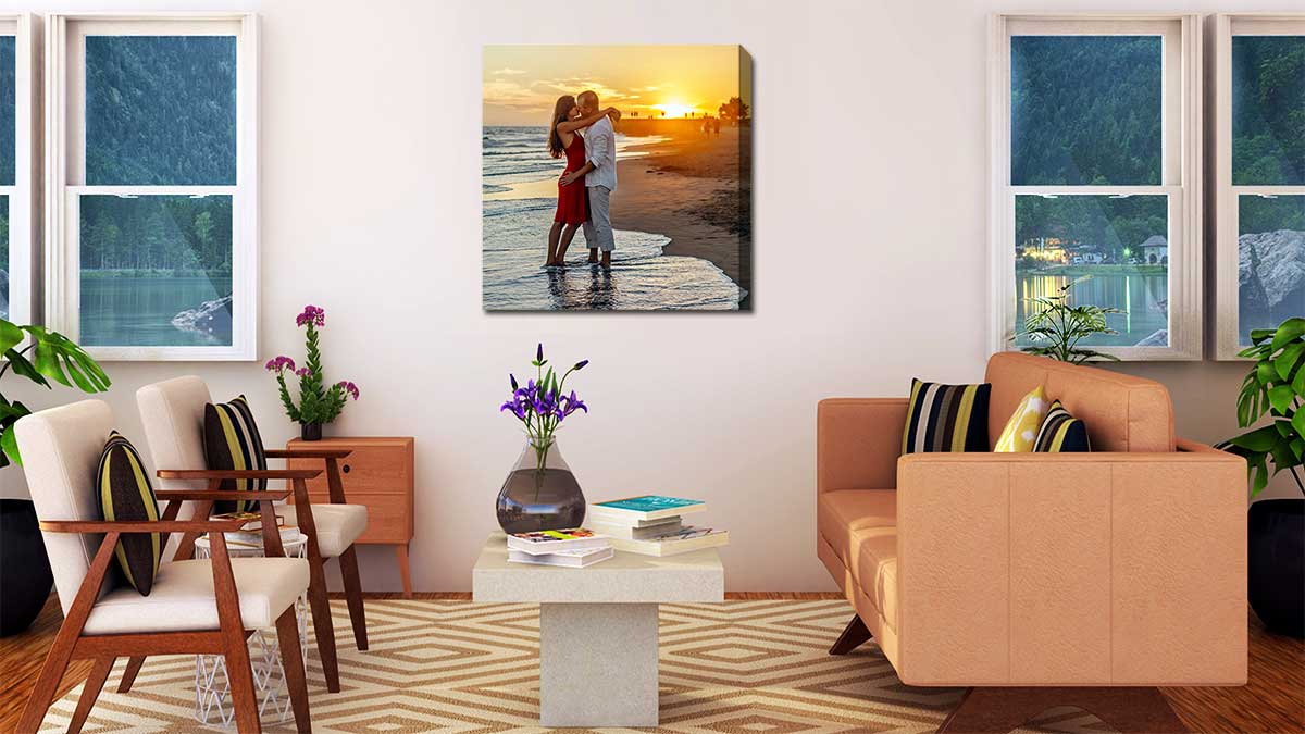 Magical honeymoon shot of a couple kissing on the beach in the sunset printed on canvas