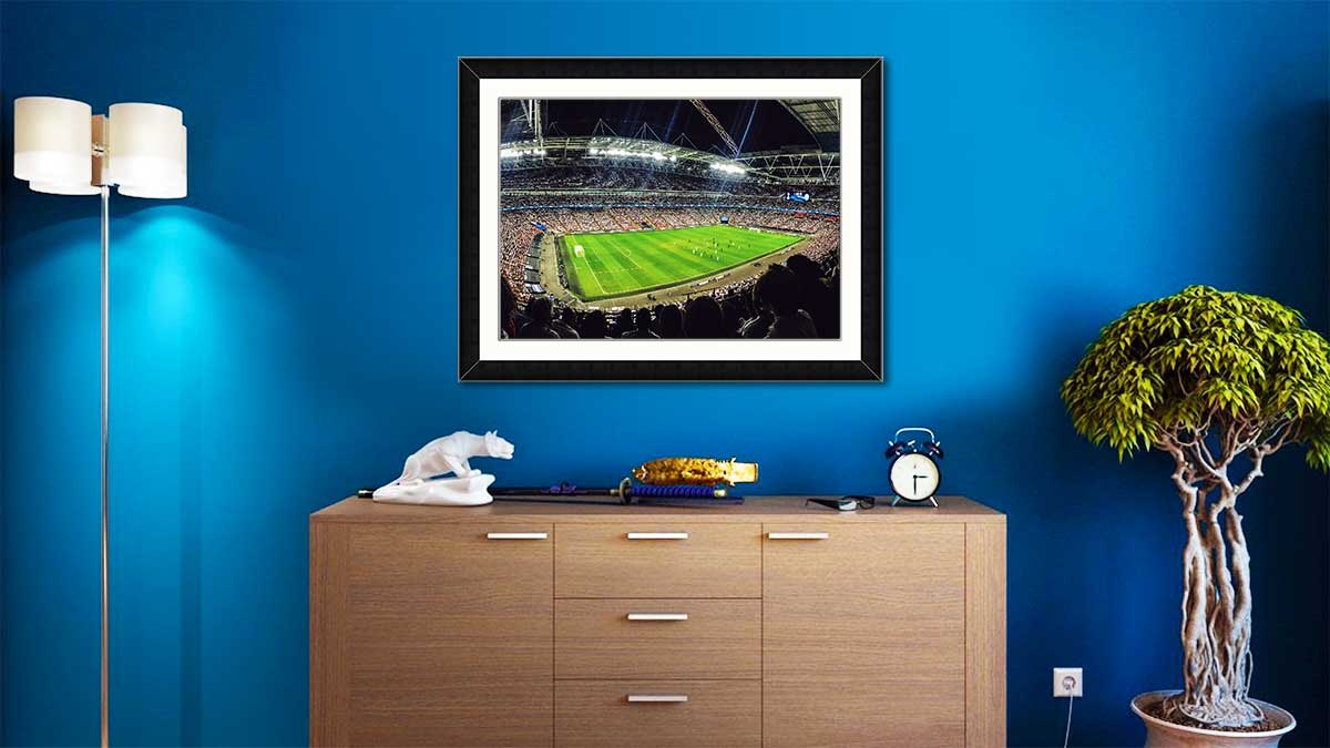 Photo of a football stadium during a game, framed in an A2 frame and hung over a sideboard.
