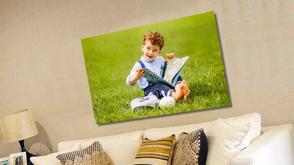A2 poster of a child sitting on the grass reading a storybook, hanging on the wall behind a sofa