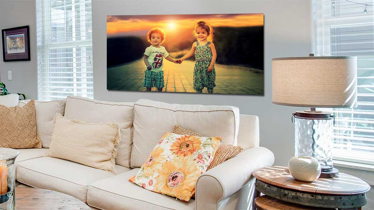 Two children holding hands in the sunset, printed on a poster and hung in a sitting room