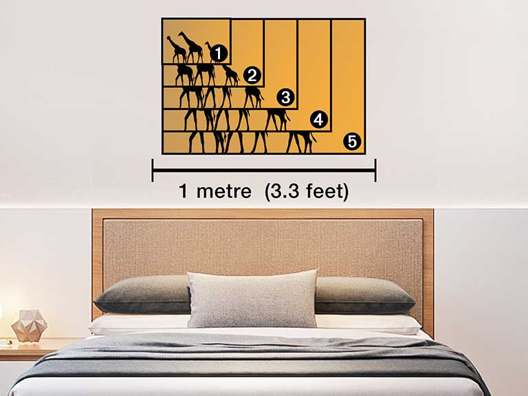 Photo of a giraffe printed on a poster hung above a bed