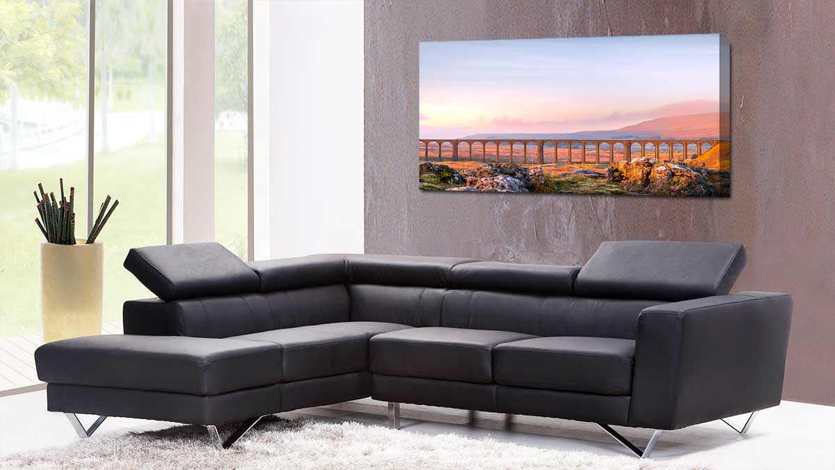 Panoramic canvas featuring a photo of a viaduct hung in a modern office