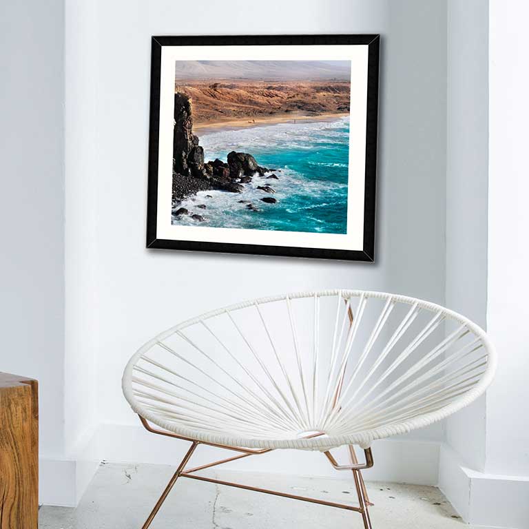 Modern loft style home with a dramatic landscape cropped and framed in a simple square frame.