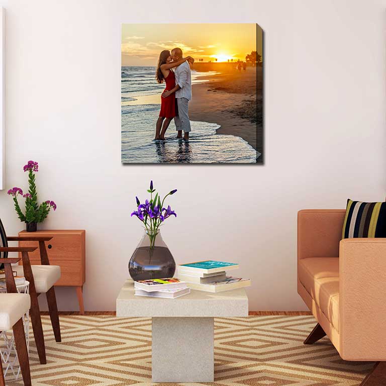 Magical honeymoon shot of a couple kissing on the beach in the sunset printed on canvas