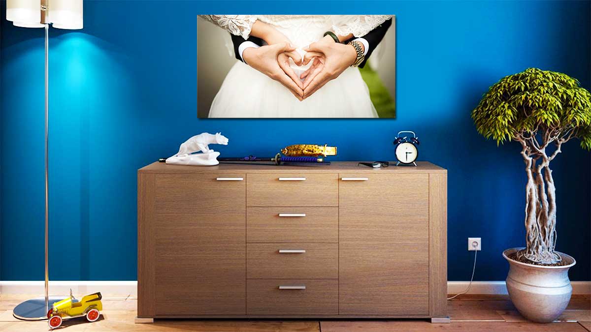 panoramic printing panoramic print of a wedding couple with their hands in a heart shape, hung over a sideboard