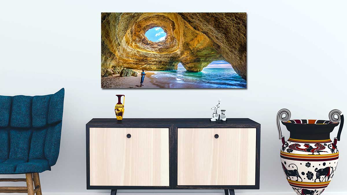 Panoramic poster print of a dramatic seascape hanging on a wall above a stylish sideboard