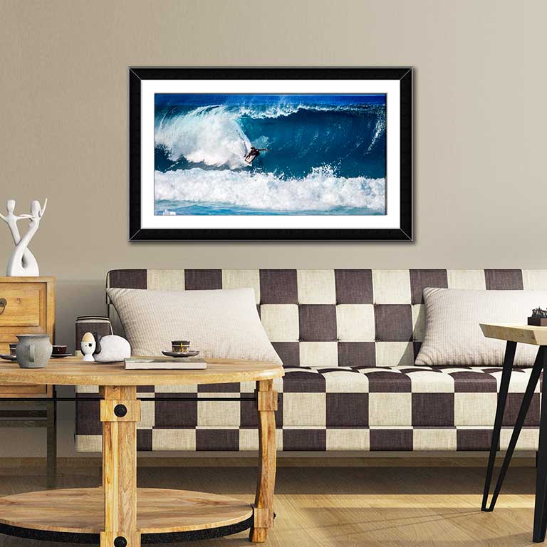 Framed picture featuring a surfer on a dramatic wave hung in an esoteric sitting room