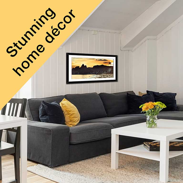 Print of a holiday photo of a beach in sunset hung on a wall in a black frame