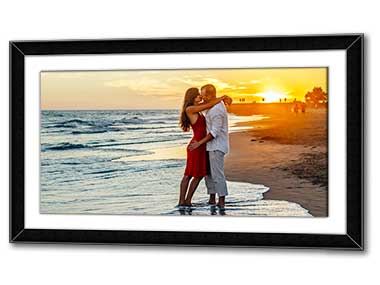 Panoramic framed poster of a honeymoon couple kissing on a beach in the sunset