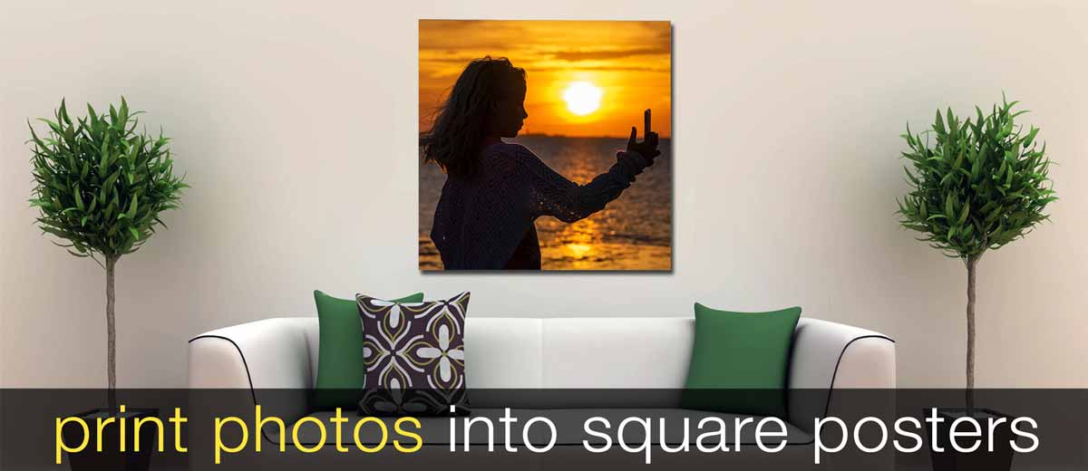 Square photo print of two children playing in water, hung above a sofa